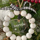 This distressed beaded wreath ornament is showing the state of Ohio and the city of Dayton cut and engraved on clear acrylic.  A red and black plaid ribbon finishes this look.