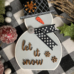 This is the small gray snowman with the saying let it snow in script.