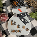 This is the small gray snowman with the saying let it snow in script.