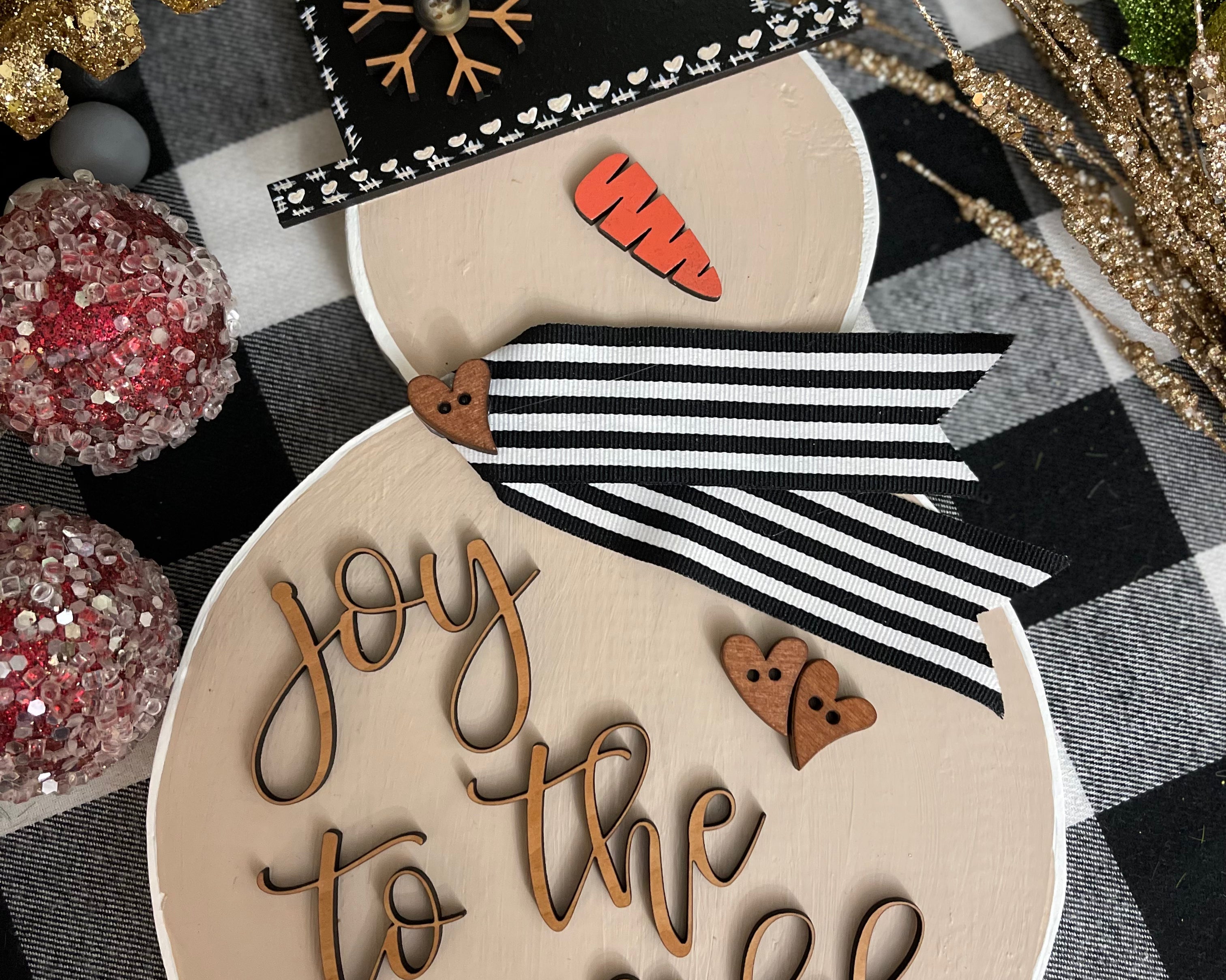 This image shows the large tan snowman that says joy to the world in script.