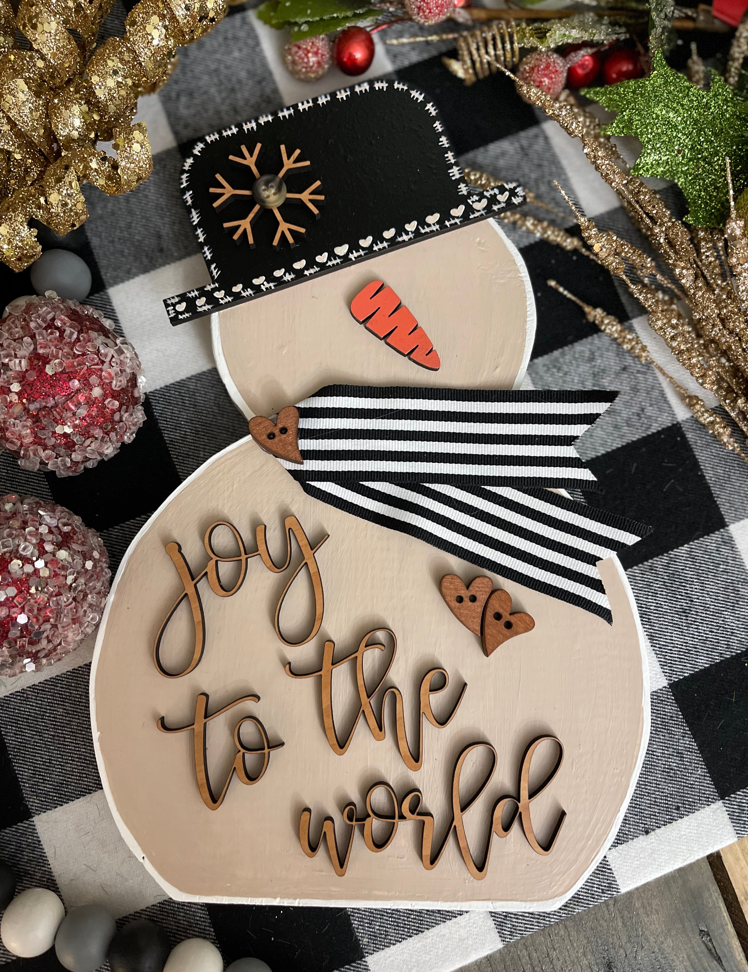 This image shows the large tan snowman that says joy to the world in script.