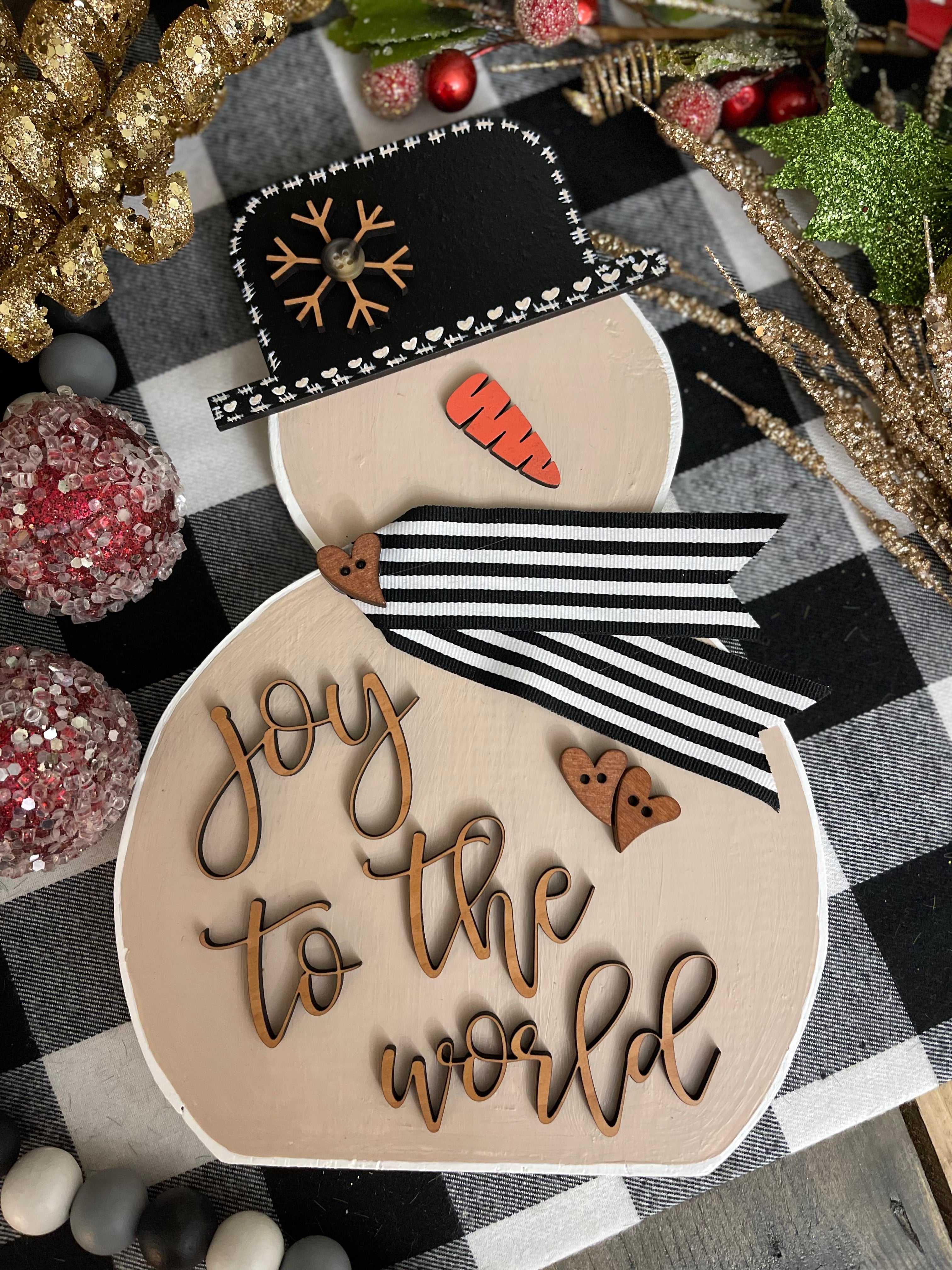 This image shows the large tan snowman that says joy to the world in script.