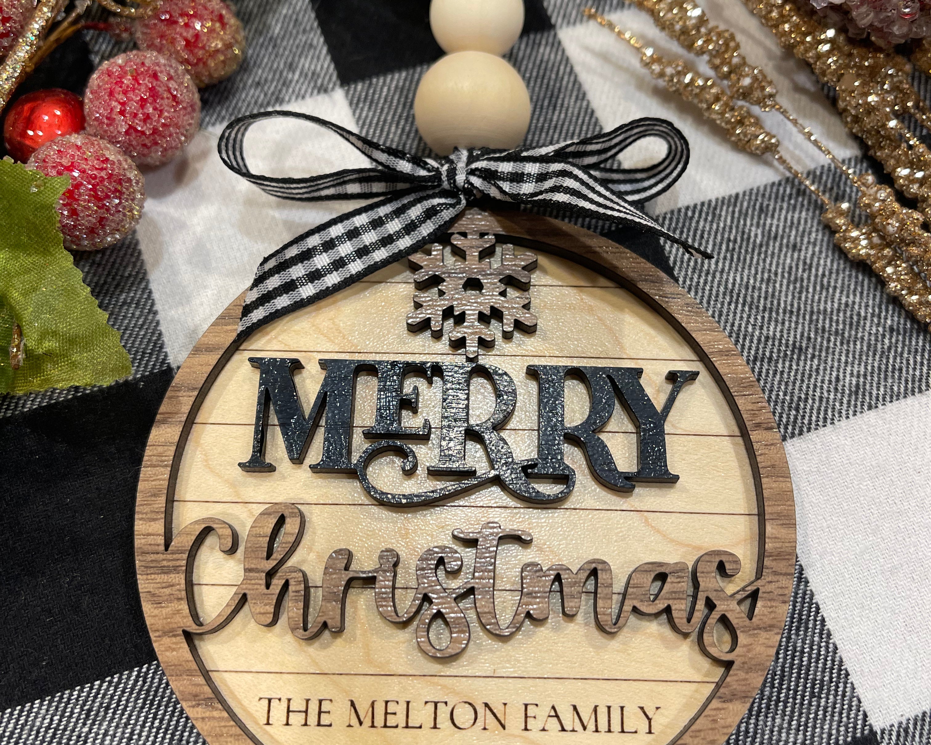 This image shows the personalized engraved family name ornament.  The colors are maple, walnut and black.