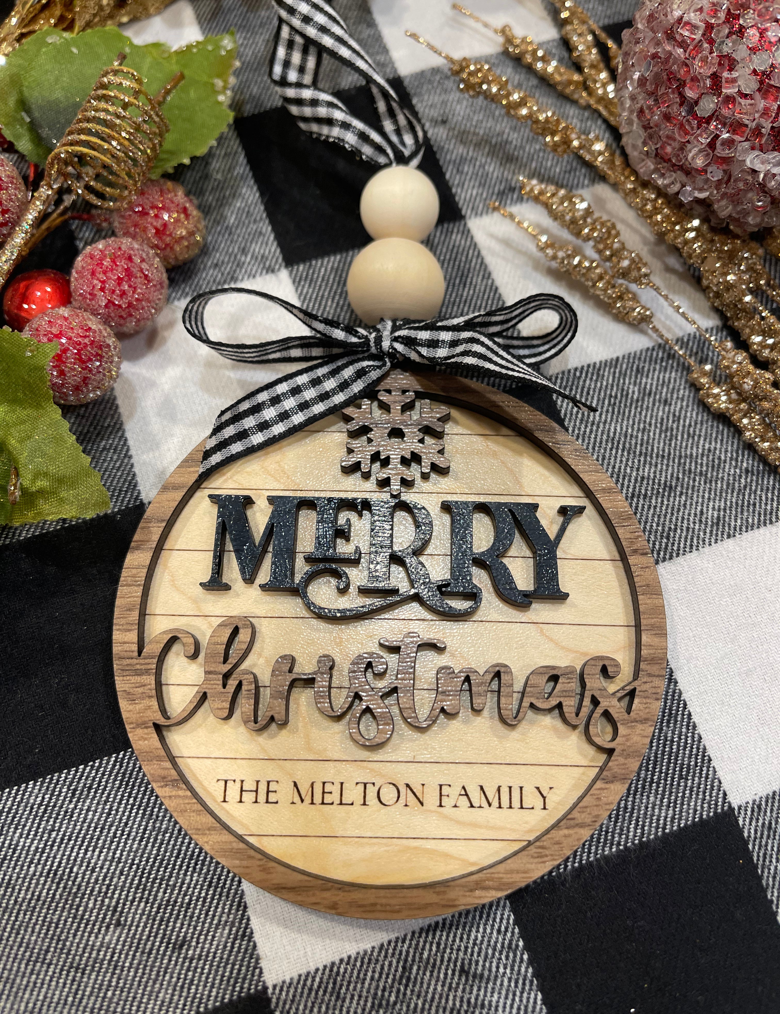 This image shows the personalized engraved family name ornament.  The colors are maple, walnut and black.