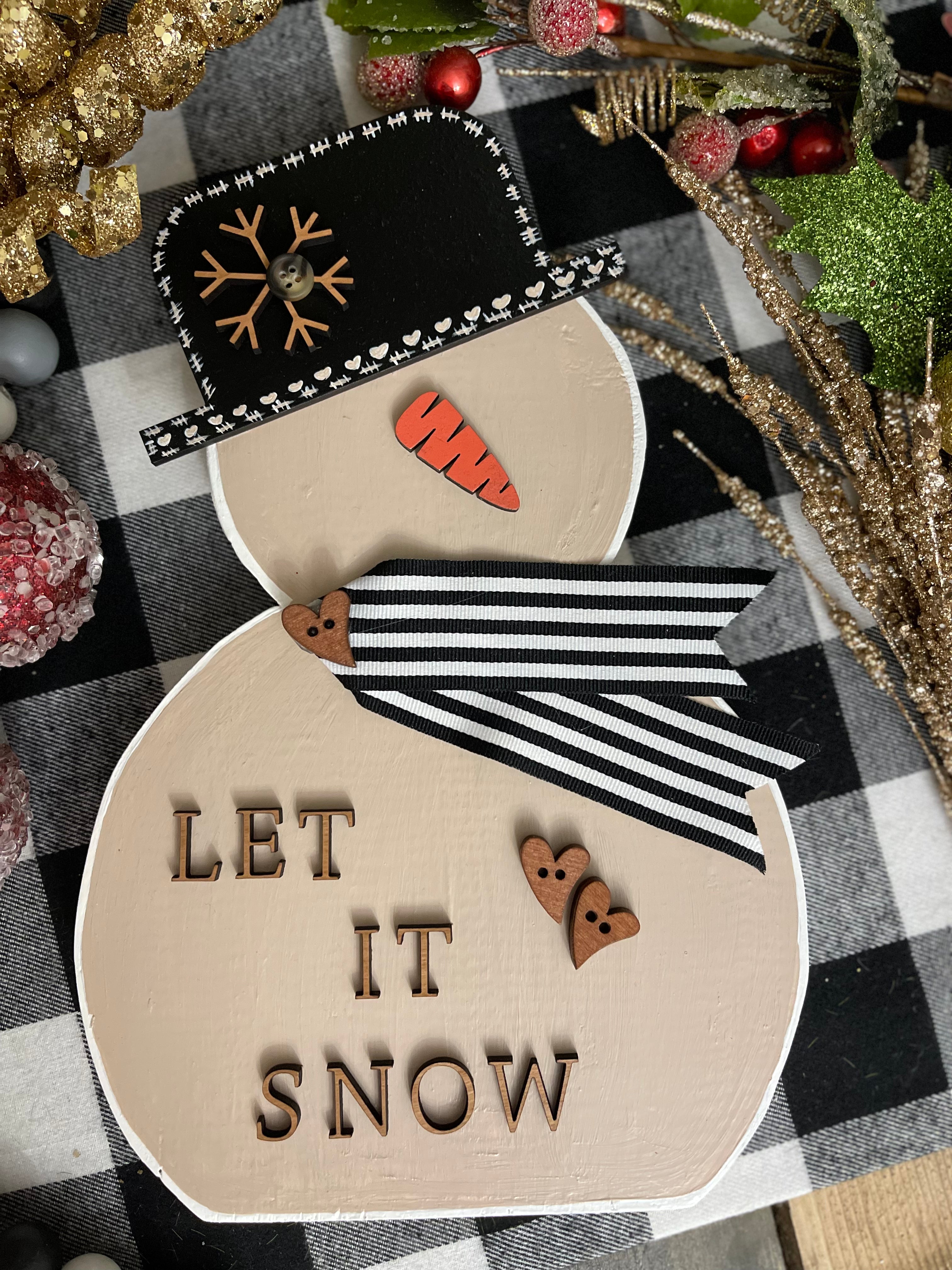 This is the large tan snowman with the saying let it snow in print.