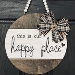 This is Our Happy Place Shiplap Door or Wall Hanger is shown hanging on a front door.  This is the 15" round shown.