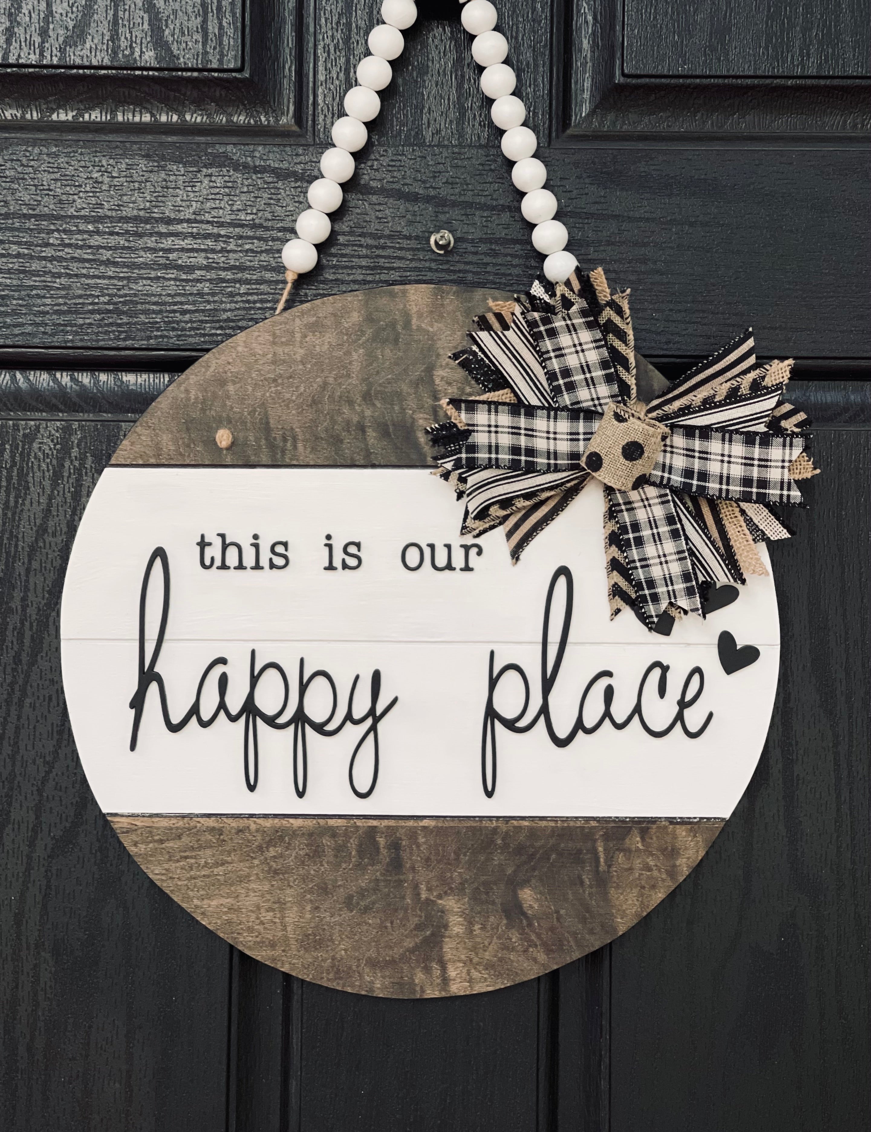 This is Our Happy Place Shiplap Door or Wall Hanger is shown hanging on a front door.  This is the 15" round shown.