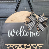Welcome Shiplap Door or Wall Hanger with Leopard Print shows the 15" round hanging on a front door.